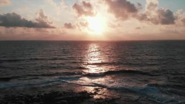 Ufukta muhteşem bulutlu gökyüzü ile güneş yolu ve dev okyanus dalgaları ile güzel pembe günbatımı havadan drone görünümü