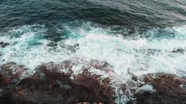 Close-up bovenaanzicht van grote witte golven raken Zee rotsen tijdens storm — Stockvideo