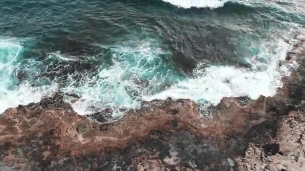 Drone vliegt door rotsachtige oever van vulkanische eiland gewassen door de Middellandse Zee — Stockvideo