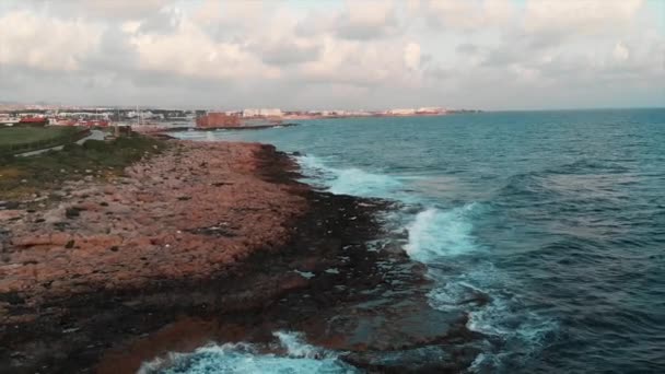 Drone vista de la costa rocosa con hermoso paseo marítimo peatonal verde y enormes olas marinas que chocan con el arrecife — Vídeos de Stock