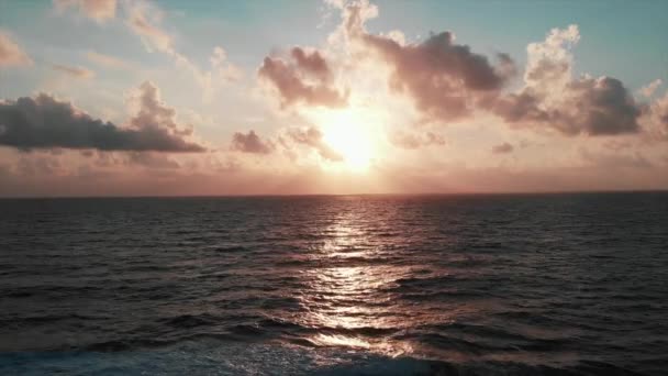 Vista aérea de la hermosa puesta de sol rosa con increíble carretera solar y enormes olas marinas que chocan con rocas, creando espuma blanca y salpicaduras — Vídeo de stock