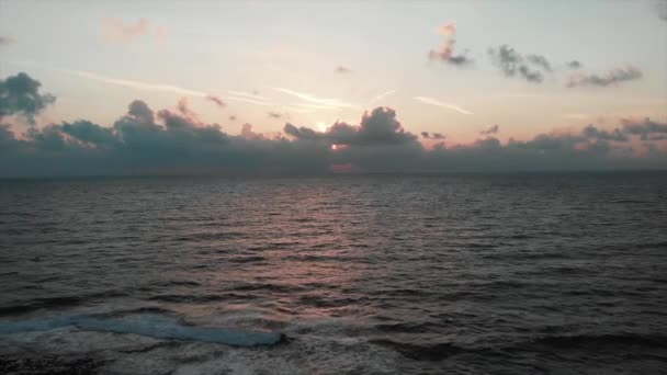 Zomerzon ondergaat een prachtige Middellandse Zee met golven die rotsachtige kust raken. Luchtfoto drone weergave — Stockvideo