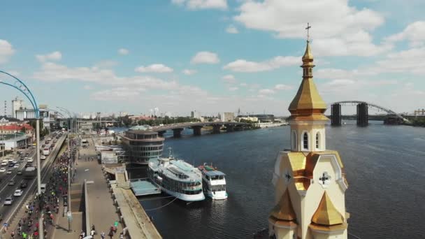 Vista aérea del muelle de la ciudad de Kiev con columna de ciclistas felices montando a lo largo del río Dnipro en el soleado día de verano — Vídeos de Stock