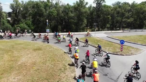 Gros plan drone vue du groupe de cyclistes sportifs attractifs en vêtements lumineux profiter de la promenade dans un parc récréatif vert avec une belle nature — Video