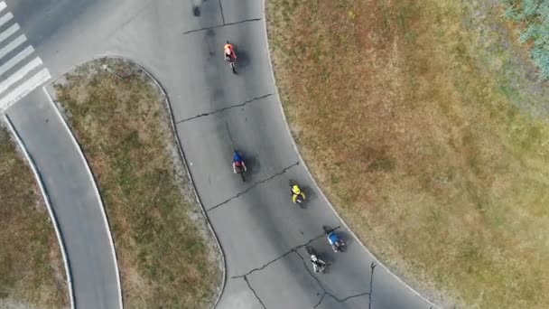 Drone top shot of cyclists riding on road in Muromets Park at sunny summer day — Stock Video