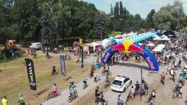 Kiev/Ukraine-June,1 2019 Group of bike riders passing finish line with relaxing area in Muromets park at sunny summer day — 비디오