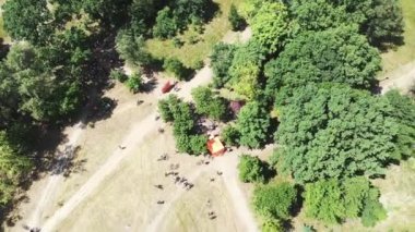 Güneşli yaz gününde yarışa hazırlanan bisikletçiler grubu ile yeşil şehir parkıhavadan üst görünümü