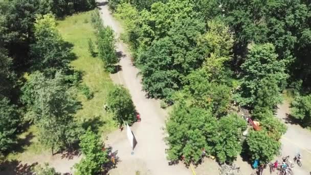 Drone-weergave van groen rustgebied met toeristisch pad en fietsers in een prachtig park — Stockvideo