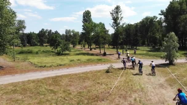 Groep jonge mannelijke fietsers jagen leider op Mountain bike race in Muromets Park — Stockvideo