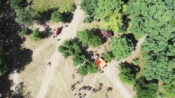 Drone flyger runt startområdet cykelloppet i grön skog på soliga sommardagen — Stockvideo