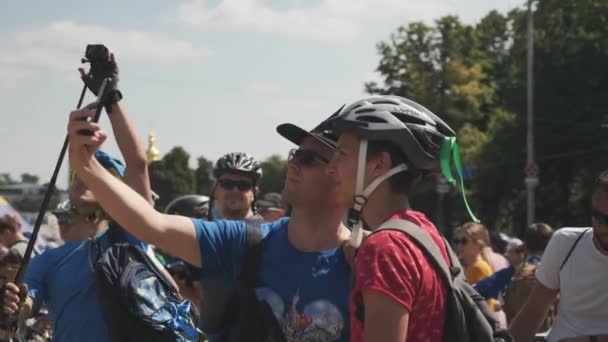 Kiev / ukraine-juni, 1. 2019 zwei Freunde in sportlicher Kleidung machen Selfies bei Fahrradparade — Stockvideo