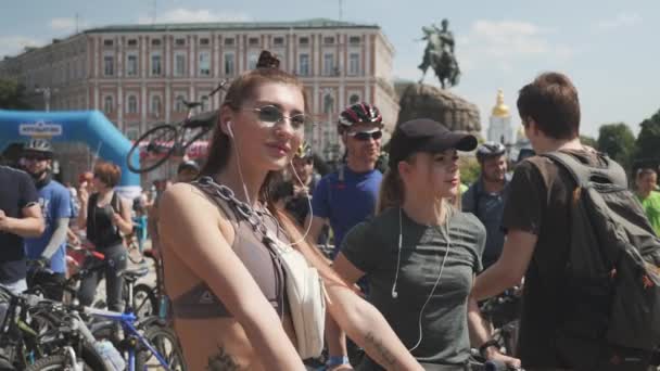 Kiev / Ucrania-junio, 1 2019 Joven chica atractiva triatleta caliente con auriculares en sujetador deportivo está de pie cerca de su bicicleta y disfrutar del sol en el día de la bicicleta. Movimiento lento — Vídeo de stock