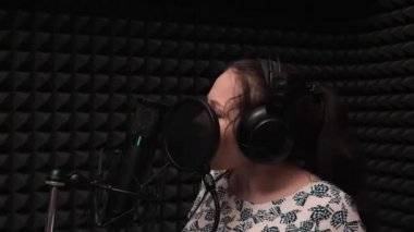 Müzik kaydı. Şarkının ses kaydı. Stüdyoda şarkı söyleyen kız. Müzik ev stüdyosunda kadın portresi