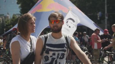 Kiev/Ukrayna-Haziran,1 2019 Erkek arkadaşıyla konuşan ve bisiklet gününde gülümseyen genç çekici kızın portresi. Yavaş çekim