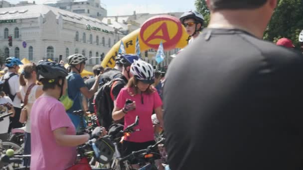 キエフ/ウクライナ-6月、1 2019明るい服とヘルメットでスポーティな魅力的なバイクライダーは、市内中心部でサイクリングパレードを待っています。スローモーション — ストック動画