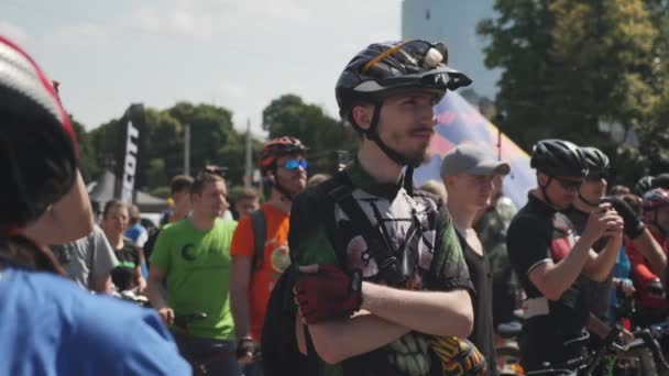 Киев / Украина-1 июня 2019 г. Портрет молодого велосипедиста в зеленой майке и велошлеме на велосипедном параде. Медленное движение — стоковое видео
