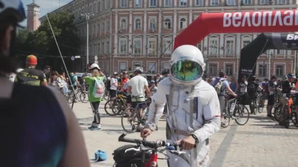 Kijów/Ukraina-czerwiec, 1 2019 mężczyźni w kostium kosmonauta z rowerem. Rowerzysta w białym garnitur astronauty. Młody chłopak z rowerem na paradzie rowerowej w Kijowie. Parada rowerowa. Zwolnionym — Wideo stockowe