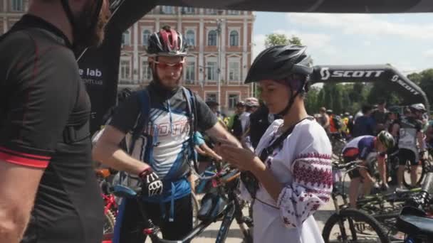 Kyjev/Ukrajina-červen, 1 2019 ukrajinská dívka s pohledem na telefon. Žena v národním kostýmu se usmívá na kameru. Portrét dívky v cyklistice v Kyjevě. Zpomaleně — Stock video