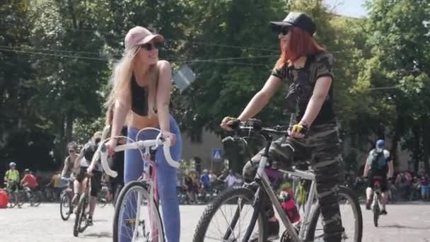 Kiev/Oekraïne-juni, 1 2019 jonge hete meiden op fietsen. Leuke vrouwen praten en glimlachen. Aantrekkelijk meisje op roze retro fiets. Schattige meiden houden fietsen bij Cycling Parade. Meisje in kaki kleding op de fiets — Stockvideo