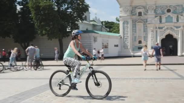 Kijów/Ukraina-czerwiec, 1 2019 Sportive kobieta jazda rowerem w centrum miasta. Portret atrakcyjnej kobiecej rowerzysty w niebieskiej górze i czarno-białych legginsach. Atrakcyjna dziewczyna na niebieskim rowerze górskim. Dzień rower w Kijowie. Zwolnionym — Wideo stockowe