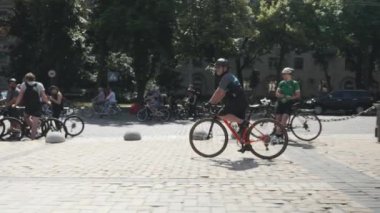 Kiev/Ukrayna-Haziran,1 2019 Şehir merkezinde turuncu bisiklete binen adam. Bisiklet geçit töreninde bisiklete binen kask lı bisikletçi ve güneş gözlüğü. Kiev'de bisiklet günü. Bisiklet konsepti. Yavaş çekim