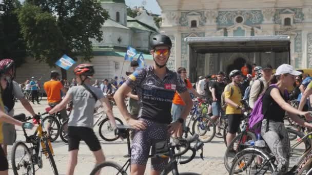 Kiev / ukraine-juni, 1. 2019 attraktiver Radfahrer lächelnd und winkend. Porträt eines süßen Jungen in Radlerkleidung und Sonnenbrille. zufriedene Fahrradfahrer lächeln in die Kamera. Fahrradkorso. Zeitlupe — Stockvideo