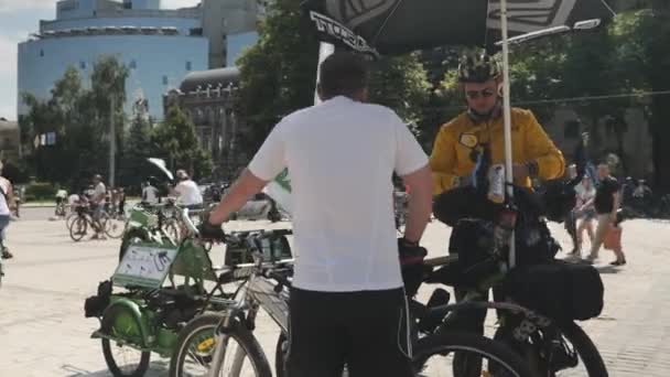 Kijów/Ukraina-czerwiec, 1 2019 zbliżenie rowerzysty stoi w pobliżu roweru z wózkiem rowerowym. Dwóch rowerzystów rozmawia na paradzie rowerowej. Zamknij rower z bagażem i wózkiem rowerowym. Parada rowerowa w Kijowie — Wideo stockowe