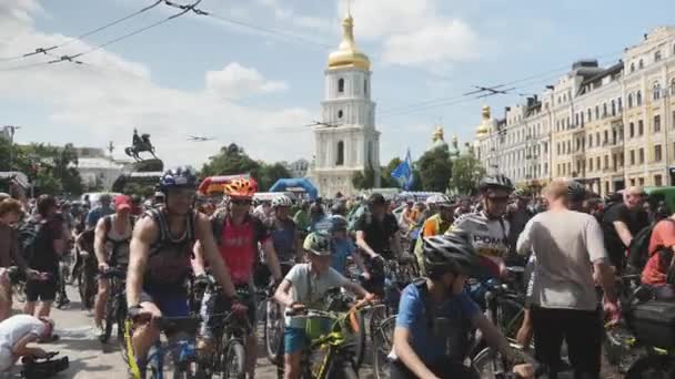 Киев / Украина-1 июня 2019 года Группа велогонщиков в центре города на день велосипеда. Участники велопарада у площади в Киеве. Молодые симпатичные девочки и мальчики на велосипедах — стоковое видео