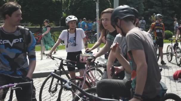 Kiev / Ucrania-junio, 1 2019 Acercamiento de jóvenes ciclistas atractivos en bicicletas de montaña. Chica en bici retro rosa. Los motociclistas se ríen del desfile. Movimiento lento — Vídeo de stock