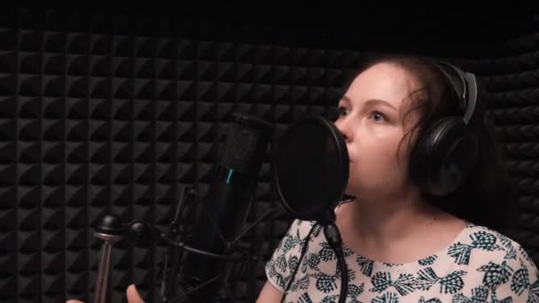 Pop kadın sanatçı mikrofona şarkı söylüyor. Kayıt vokal stüdyosu — Stok video