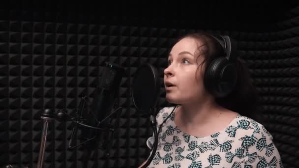 젊은 로맨틱 한 여성 가수는 녹음 보컬 스튜디오에서 감정적으로 노래. 음악 리허설 — 비디오