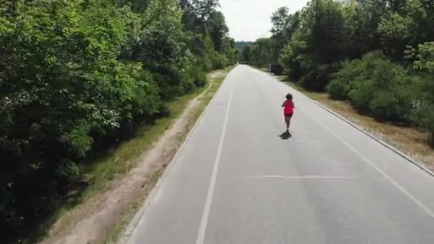 Attractive femme sportive en rose vêtements de sport s'entraîne dur dans le parc de la ville. Mince fille brune faisant des exercices. Belle coureuse sportive pratique des entraînements de course — Video