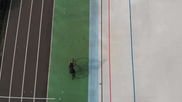Velódromo en Kiev. Chica en bicicleta de carretera en el velódromo abierto. Drone vista superior de ciclista femenina en pista de ciclismo . — Vídeos de Stock