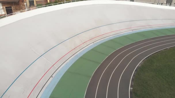 Jonge fietsers op vaste tandwiel fiets fietsen bij Velodrome. Drone-weergave van professionele fietsers zijn trappen op de fiets baan. Cycling concept — Stockvideo