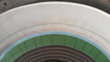 Velodrome üzerinde yarışan profesyonel bisikletçilerin Drone üst görünümü. Bisiklet pistinde sabit vitesli bisiklet eğitimi genç erkek bisikletçiler. Velodrome'da yarış