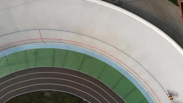 Drone flies around velodrome in Kyiv. Professional cycling team training on cycling track.  Young sportive men on track bikes riding at velodrome — Stock Video