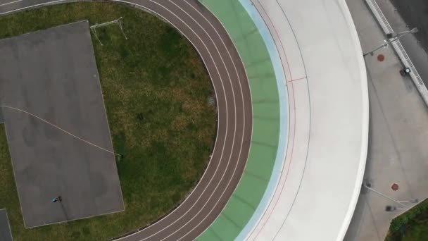 Velodrome in Kyiv from bird's eyes view. Young motivated girl training at velodrome. Sportive cute woman on road bike riding on cycling track — Stock Video