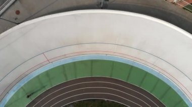 Genç sevimli kız velodrome sabit vitesli bisiklete binmek için öğrenme. Kız bisiklet pistinde yavaş yavaş bisiklet. Velodrome'da sportif kadın eğitimi