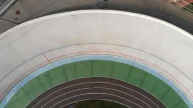 Velodrome'daki bisiklet yarışmasının drone üst görünümü. Bisiklet pistinde yarışan pistteki güçlü bisikletçiler. Velodrome'da eğitim
