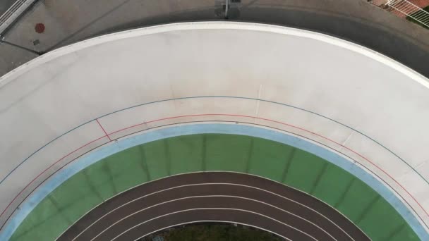 Drone vista superior de la competencia ciclista en velódromo. Fuertes ciclistas en bicicletas de pista que compiten en pista de ciclismo. Formación en velódromo — Vídeos de Stock