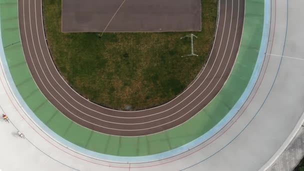 Vzdušný pohled na cyklistickou dráhu se dvěma cyklistiky. Intenzivní výcvik mužských cyklistů v velodromu. Drone pohled na velodrom v Kyjevě — Stock video