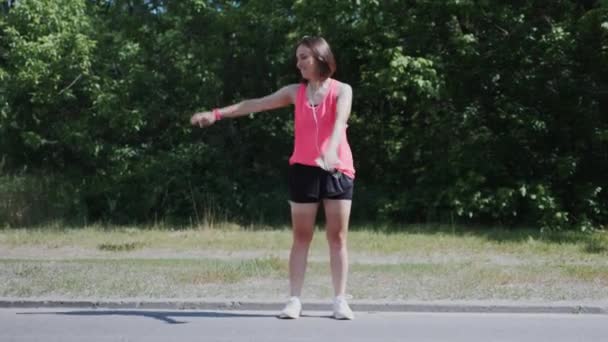 Ung attraktiv flicka gör DAB flytta i parken. Sportiga kaukasiska kvinnan gör roliga rörelser och ha kul. Flicka leende och skrattar — Stockvideo