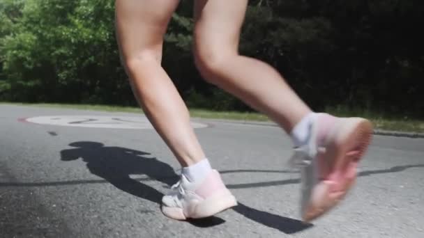 Zavřete pohled na cvičené nohy s celulitulitem. Aktivní sportivní dívka v parku. Atraktivní ženská trénink v parku. Štíhlá motivovaná a koncentrovaná dívka provádí cvičení. Průběžný koncept. Zpomaleně — Stock video