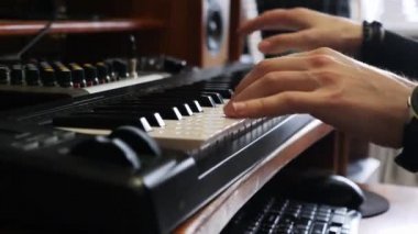 Dijital saat ile piyano elektronik klavye üzerinde oynayan eller. Müzik kayıt stüdyosu konsepti. Müzisyen stüdyoda şarkı üretiyor. Şarkı kayıt işlemi.