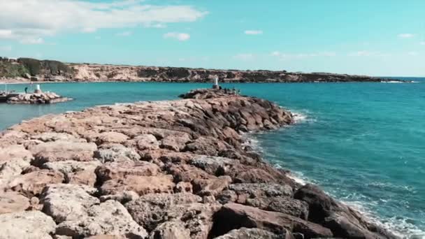 Rocky Sea Pier med havsvågor slår klippor skapa vitt skum och vattenstänk. Flygfoto över Medelhavet Coral Bay Rocky Pier på Windy solig dag. — Stockvideo