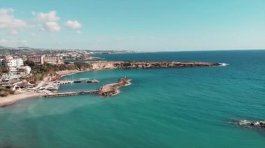 Okyanus plajının güzel manzarası. Turkuaz berrak su ile deniz. Güzel kayalık sahil şeridi. Kıbrıs adasının havadan görünümü. Akdeniz'in kumlu plajı ile drone çekimi
