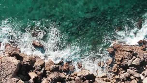 的鸟顶视图。岩石海岸的无人机拍摄。具有极端海浪的海上海岸线。波浪击中岩石。海浪冲击岩石海滩。海浪飞溅 — 图库视频影像