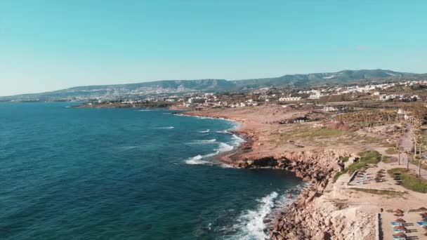 Luftaufnahme der felsigen Meeresküste. Drohnenschuss von Klippen. Meereswellen krachen auf Klippen an der Küste. Drohnenblick auf die Küste der Insel Zypern. Luftaufnahme des Touristengebiets. Paphos, Insel Zypern — Stockvideo