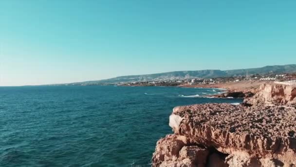 海浪。巨浪冲击岩石海滩。地中海的海浪。塞浦路斯岛。海浪飞溅在岩石悬崖海滩上的空中拍摄。暴风雨的海浪。无人机拍摄 — 图库视频影像