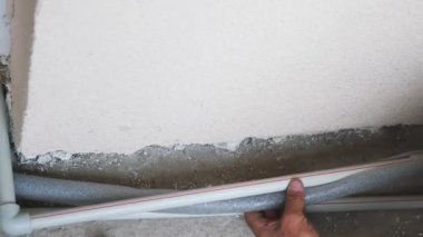 İşçi pvc kaplama ile sıhhi borular kapsar. Boru hattı kavşağı inşaat işçisi tarafından kaplama ile kaplıdır.